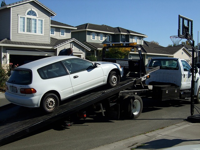 light blue car getting towed